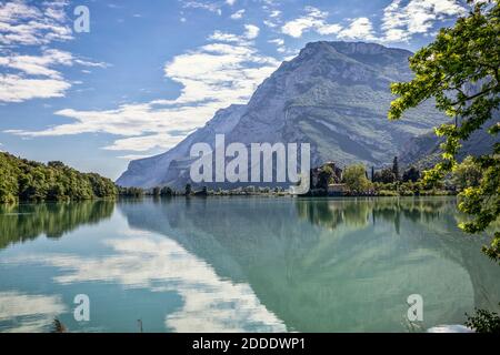 Italy, Trentino, Scenic view of mountains reflecting in Lago di Toblino with Castel Toblino in background Stock Photo