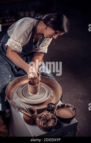 Processing clay ware and making dishes, process. Ceramics of handwork and clay ware on the potter's wheel. Stock Photo