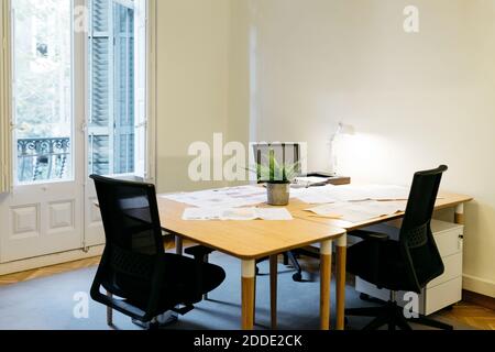 Empty chair arranged with papers over table at workplace Stock Photo