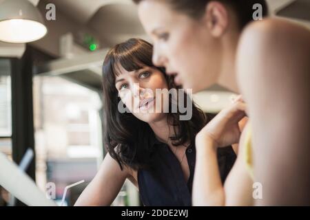 Businesswomen discussing during meeting in coffee shop Stock Photo