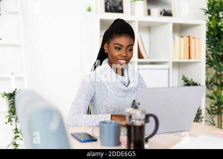 Female student studying through laptop while sitting at home Stock Photo