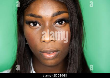 Close-up of woman face against green background Stock Photo