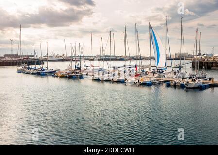 Sailing boats in a harbour lit by summer midnight sun. Lens flare. Stock Photo