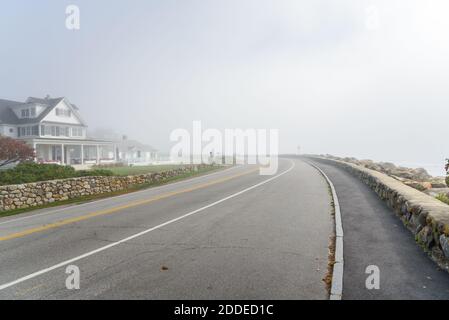 Deserted winding coastal road covered with fog on an autumn morning Stock Photo