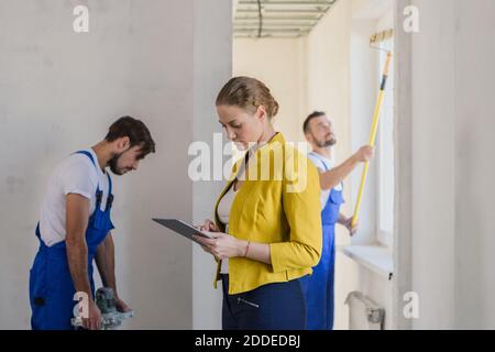 Female client evaluate the work of workers and write a note Stock Photo