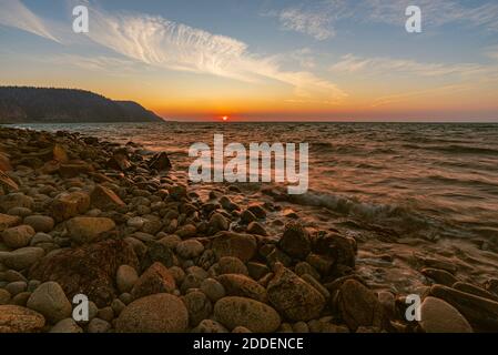 Sunset over rocky shore at low tide on bay of fundy Stock Photo