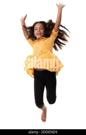 Happy multiracial small girl jumping in the air and laughing - Isolated on white Stock Photo