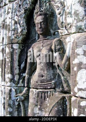 A Bayon Apsara bas-relief in the Prasat Bayon of Angkor Thom in Siem Reap, Cambodia.  The richly detailed Apsara dancer bas relief is carved in sandstone is one of many in the excavated walls of Bayon.  An apsara is a female spirit of the clouds and water transcending the Hindu and Buddhist religions. Stock Photo