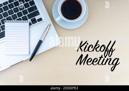 KICKOFF MEETING text with fountain pen, notepad, laptop and cup of coffee on wooden background. Business and copy space concept. Stock Photo