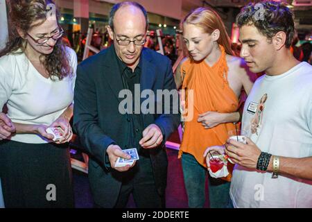Miami Beach Florida,Crunch Gym VIP Party,night entertainment magician demonstrates card trick,man woman female watches, Stock Photo