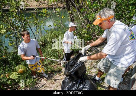 Miami Beach Florida,Dade Canal teen teens student students,Job Corps workers volunteers cleaning collecting collect trash,boys senior man plastic bag Stock Photo