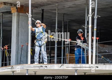 Miami Beach Florida,Dade Boulevard,new under construction site building worker wearing hardhat,tethered safety belt line dangerous job, Stock Photo
