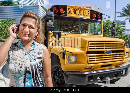 Miami Florida,Hispanic woman female school bus driver,using talking talks smartphone, Stock Photo