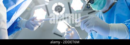 Close-up of gloved hands holding surgical equipment at the operating room, For Medical surgery banner Background Stock Photo