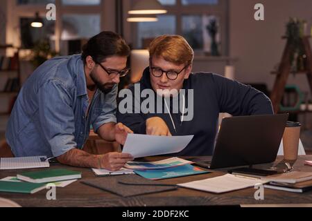 Two businessmen sitting at the table and discussing business documents in team working at office Stock Photo