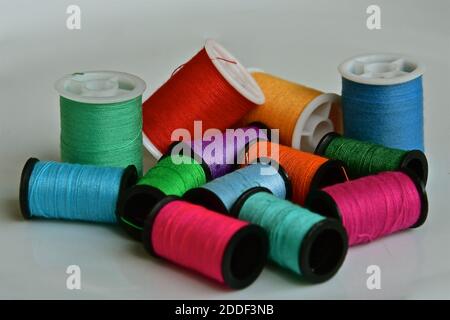 A close up perspective view of cotton bobbins of different colours and sizes Stock Photo