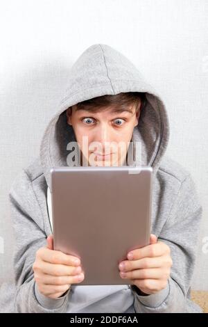 Surprised Young Man with a Tablet Computer on the White Background Stock Photo