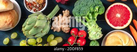 Vegan food panoramic banner. Top shot of fruits and vegetables on a dark background, healthy eating concept Stock Photo