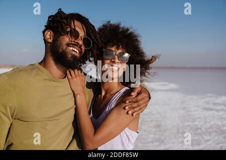 Image of happy african american couple laughing and hugging while posing in salt valley Stock Photo