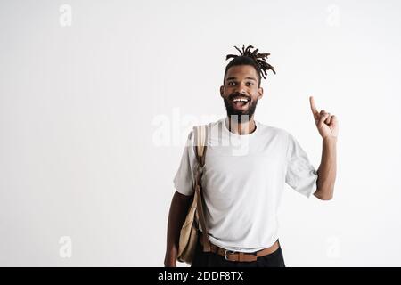 Photo of excited african american guy smiling while pointing finger upward isolated over white background Stock Photo