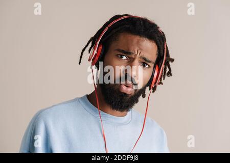 Surprised african american guy in headphones looking at camera isolated over white background Stock Photo