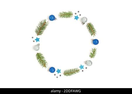 Wreath made of blue and silver Christmas decorations and spruce branches. Minimalist festive frame on a white background. Stock Photo
