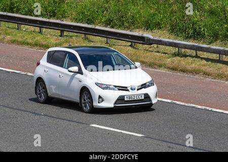 2013 white Toyota Auris Excel VVT-I CVT; Vehicular traffic, moving vehicles, electric vehicles, electric motor, EV, battery electric car ownership, hybrid, electric-powered performance cars, vehicle driving on UK roads, motors, motoring on the M6 motorway highway UK road network. Stock Photo