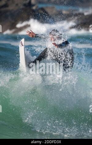 Spectacular action as a male surfer rides a wave at Fistral in Newquay in Cornwall. Stock Photo