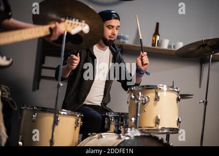 a boysband of guitarist, bassist, and drummer rehearse in their garage Stock Photo