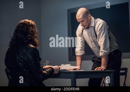 A young detective interviews a suspect in a crime. Stock Photo