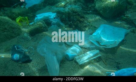 Plastic pollution - Bottles, bags and other plastic debris on seabed. Coronavirus COVID-19 is contributing to pollution, as discarded used masks clutt Stock Photo