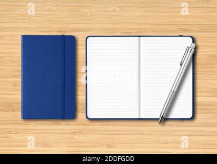 Marine blue closed and open lined notebooks with a pen. Mockup isolated on wooden background Stock Photo