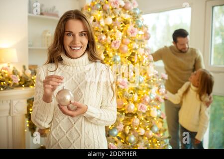 Cute happy family decorating christmas tree and feeling good Stock Photo