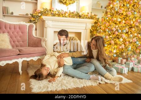 Young family feeeling happy opening christmas gifts Stock Photo