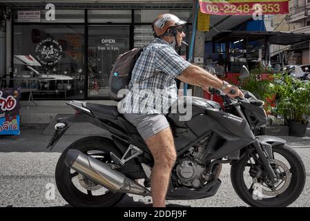 Smoking cigarette whilst riding a motorbike Stock Photo