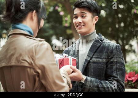young asian woman receiving a gift from boyfriend Stock Photo