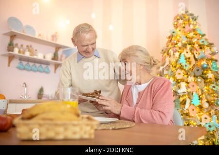 Elderly couple having breafast and feeling cheerful Stock Photo