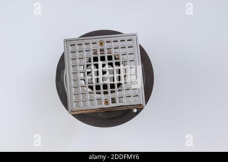 Closeup of floor drain on sewer cover in bathroom isolated on white background Stock Photo