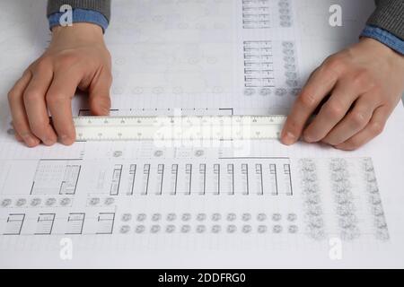 Hands using architect scale ruler on building blueprint Stock Photo