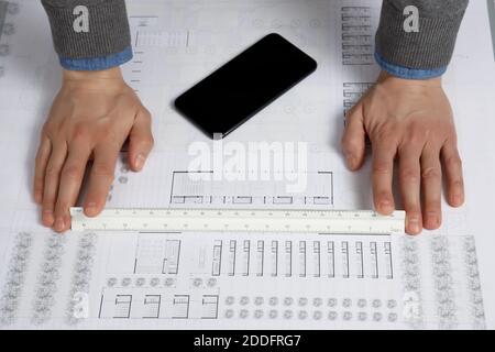 Hands using architect scale ruler on building blueprint Stock Photo