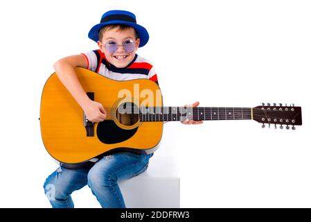 A boy kid plays guitar on a white background in the studio. Stock Photo