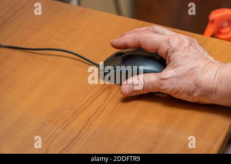 A woman uses a computer mouse. Female hand on a black computer mouse Stock Photo