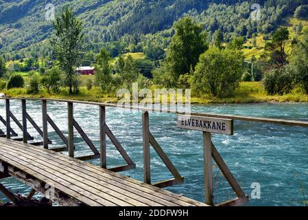 Wooden footbridge across a tributary of the Oldeelva River on the outskirts of Olden, Norway. Stock Photo