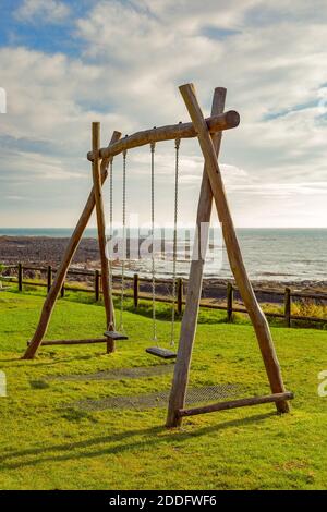 An empty set of swings in a coastal park in Fife, which we encountered whil on a staycation. The swings here are empty. Stock Photo