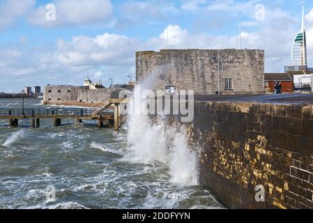 View along the seafront at Old Portsmouth, Hants, during a rough winter storm, with waves breaking against the seawall in front of the Square Tower. Stock Photo