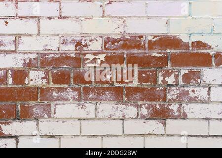 Brick wall textures. Painted problem wall surfaces. Red Stone Background. Worn facade of the building with damaged plaster. Stock Photo