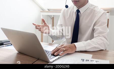 young confident male call center operator customer service representative doing his job on the phone with headset Stock Photo