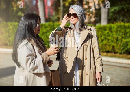Charming female friends standing on the street Stock Photo