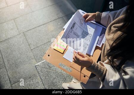 Female architect studying architectural plan on the street Stock Photo