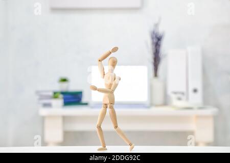 A Wooden Mannequin In A Dance Pose, On It's Stand, On A White